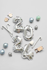 Figure 2024 made of balloons with Christmas decorations on grey background