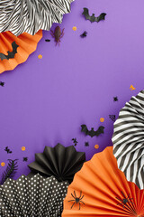 Embracing the haunting mystique of the Halloween season. Top view vertical flat lay of paper fans,...
