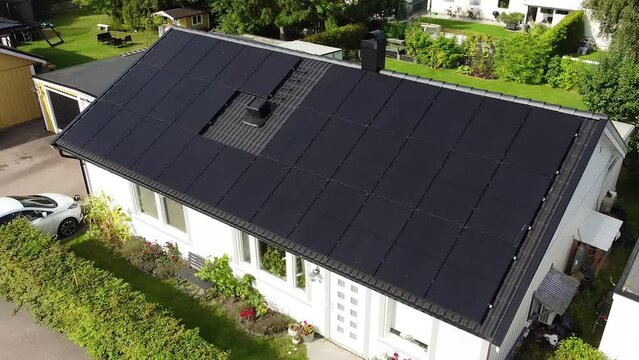 Drone circling over villa with solar panels and electric car charging