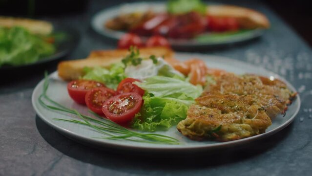 potato pancakes with salmon and salad, restaurant breakfast on a plate