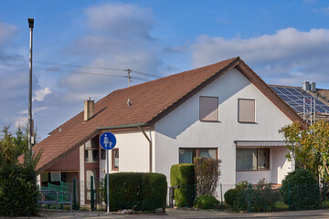 Wealthy suburb private house. Street of wealthy suburban residential houses in development housing project. A large private country house with a green trimmed lawn. Sunny summer day and blue sky