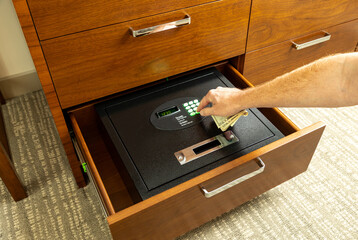 Hand opening safe in hotel room to store valuables