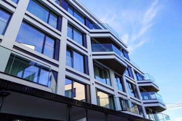 Close up view of new modern building with apartments in a new district in Kalamaja, Tallinn, Estonia. Glass windows. Blue sky with white clouds on the back