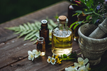 Assortment of pure organic natural essential aroma oil with mint , camomile on wooden background. Concept of herbal, floral ingredients in cosmetology. Alternative medicine, therapy, Ayurveda