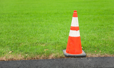 construction cone on the road signifies ongoing progress, caution, and temporary disruption in the...