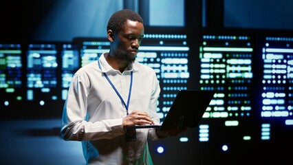 African american specialist ensuring server farm systems provide redundancy, automatic failover and...