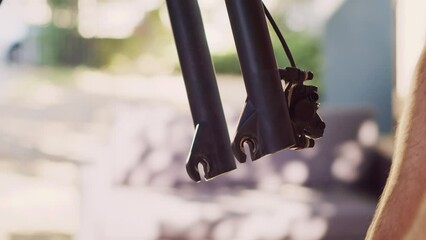 Detailed view of caucasian person detaching tire from bike front fork for annual maintenance. Healthy man dismantling damaged bicycle wheel to repair with expert work tool for cycling. Close-up shot.