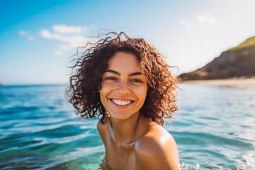 Portrait of beautiful young caucasian woman smiling and having fun while swimming in ocean