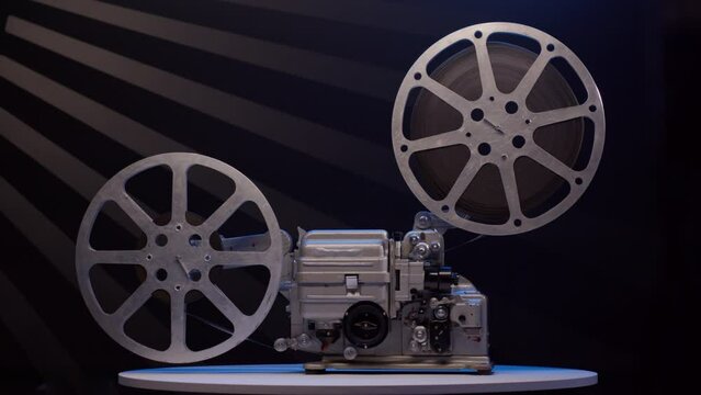 antique classic movie projector ideal for screening films. Vintage 16mm cinema projector rotate on dark background. Symbolizing nostalgia of bygone era motion pictures and magic of silver screen.