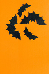 Paper bats on an orange background, Halloween concept