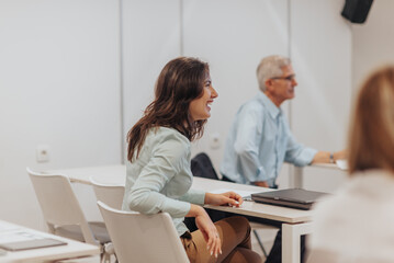 Brunette girl laughing after the business trainer joked with an employee during presentation at the classroom