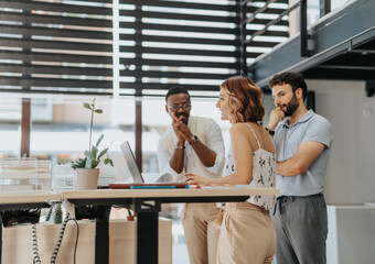 Young successful entrepreneurs working together at modern office, analyzing reports and statistics, discussing. Working in a positive atmosphere.