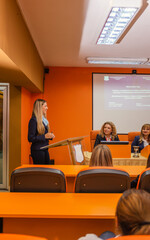 Young university student defending her diploma in the conference room