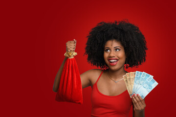 a woman holds shopping bags and Brazilian money, a teenage Afro-Brazilian girl smiles in a red dress against a red background