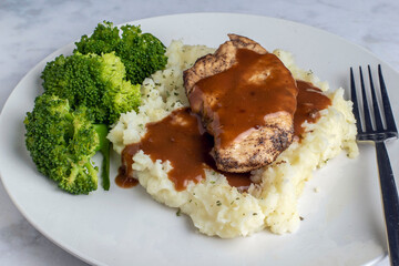 seasoned chicken breast  on mashed potatoes with gravy