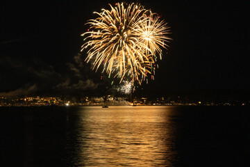 Bright Fireworks bursting in sky over ocean in Comox British Columbia