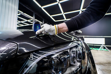 Measuring the thickness of a car paint coating with a thickness gauge
