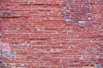 Old red brick wall with patches in the background