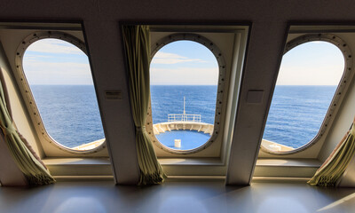 Windows looking out to bow of cruise ship and blue open ocean