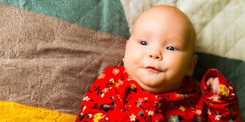 Portrait of a cute little baby girl lying on the bed.