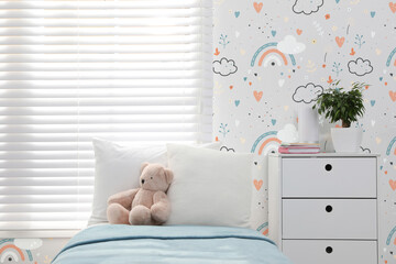 Modern room interior for child with comfortable bed near window and cute wallpapers