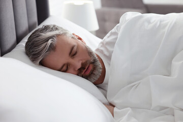 Man snoring while sleeping in bed at home