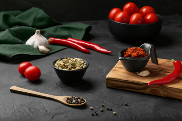 Dish with red curry paste and ingredients on black table