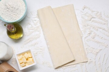 Fresh dough and different ingredients for making baklava on white table, flat lay