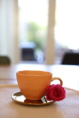 Cup of hot drink and red rose on table indoors. Space for text