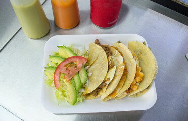 Tacos de maíz con guisados mexicanos, lechuga, aguacate y tomate. comida callejera en México. 