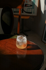 Homemade peach ice tea on wooden table under sunlight. Summer cold fruit drink in sunny afternoon. Fruit tea with ice.