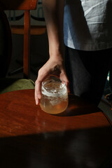 Homemade peach ice tea on wooden table under sunlight. Summer cold fruit drink in sunny afternoon. Fruit tea with ice.