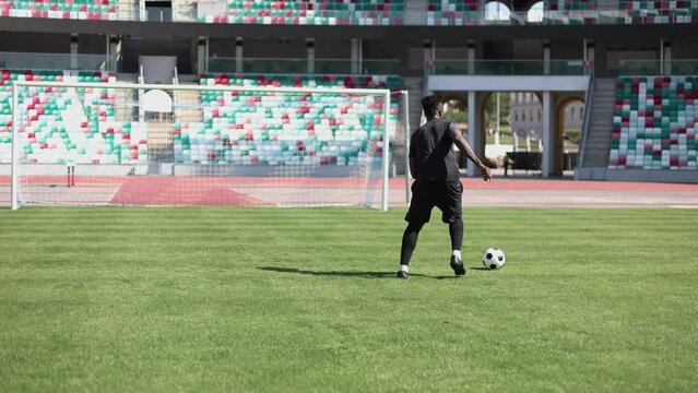 young african american man kick the ball towards the goal in training.