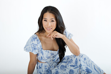 Asian young woman in summer dress against white background