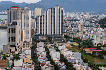 Nha Trang from the drone. In the background, a view of the city and skyscrapers. Between the buildings, a Catholic church and white houses. Vietnam