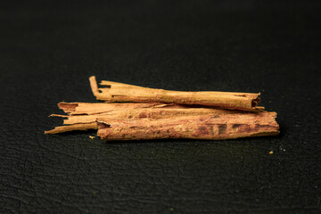 Cinnamon sticks on a black background. Selective focus.