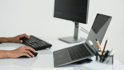 Hands of developer programmer using mouse and typing on keyboard to programming and developing web
