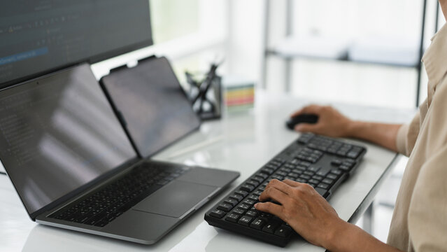 Developer programmer checking code on multiple monitor while programming to developing web and apps