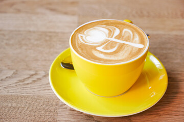 a cup of late coffee with flower shape design on top at cafe 