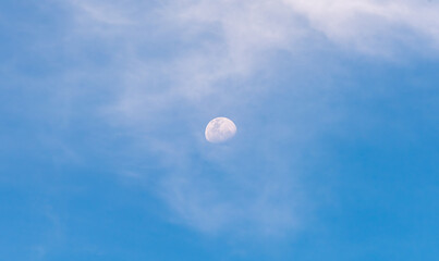 A Waning Gibbous moon against a blue with light clouds, as seen from Melbourne, Australia
