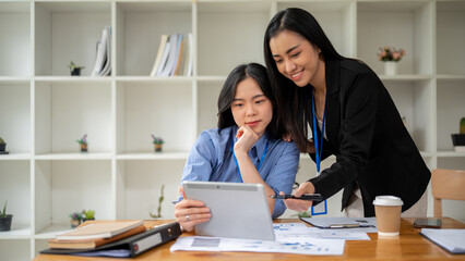 Two professional Asian businesswomen are discussing work. Teamwork concept