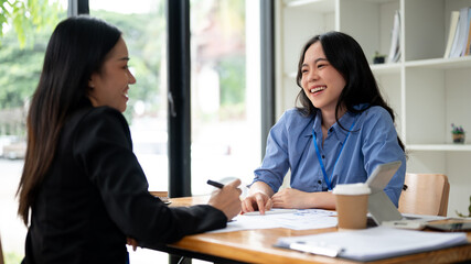 An attractive Asian businesswoman or female financial consultant enjoys talking with her client