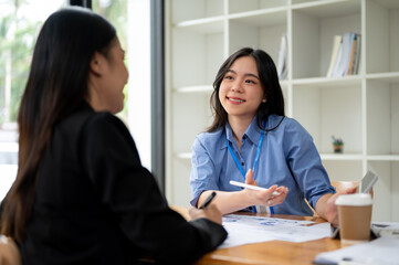 Obraz premium A businesswoman is talking and explaining financial profit to a female client in the office.