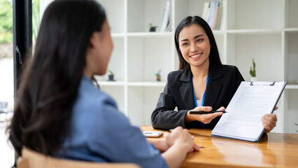 A businesswoman or sales agent is explaining the contract agreement while having a meeting