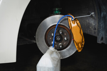 Car brake fluid bleeding service in garage service shop.