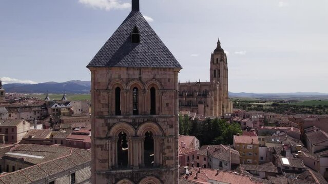 Aerial View Of Church Tower Of San Esteban With View Of Segovia Cathedral In Background On Sunny Day. Ascending Shot