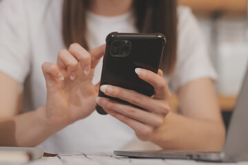 Cropped photo of Freelancer business Asian woman holding coffee cup and at doing planning analyzing the financial report, business plan investment, finance analysis the workplace.