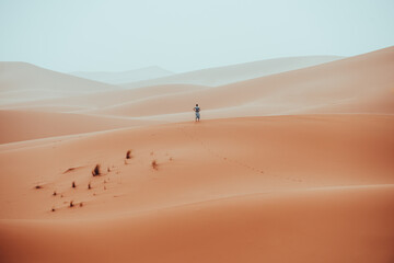 Fototapeta na wymiar Incidental local berber man wandering through Sahara Desert Merzouga, Morocco
