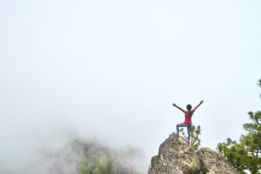 girl in top of rock in front on foggy landscape in mountains in mexiquillo durango 