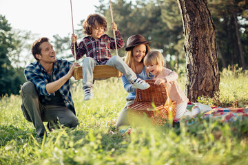 Young caucasian family having a picnic on a grassy field in nature